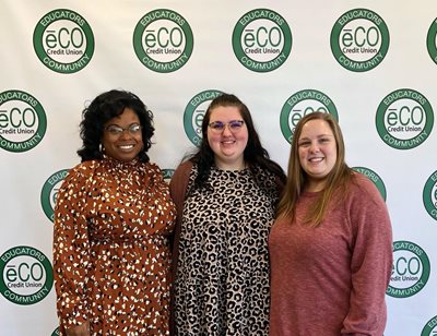 McCalla branch employees pose in front of the Step N Repeat