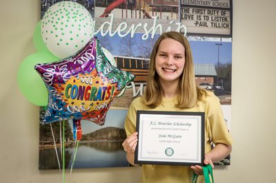 Josie McGuire poses with her scholarship certificate.